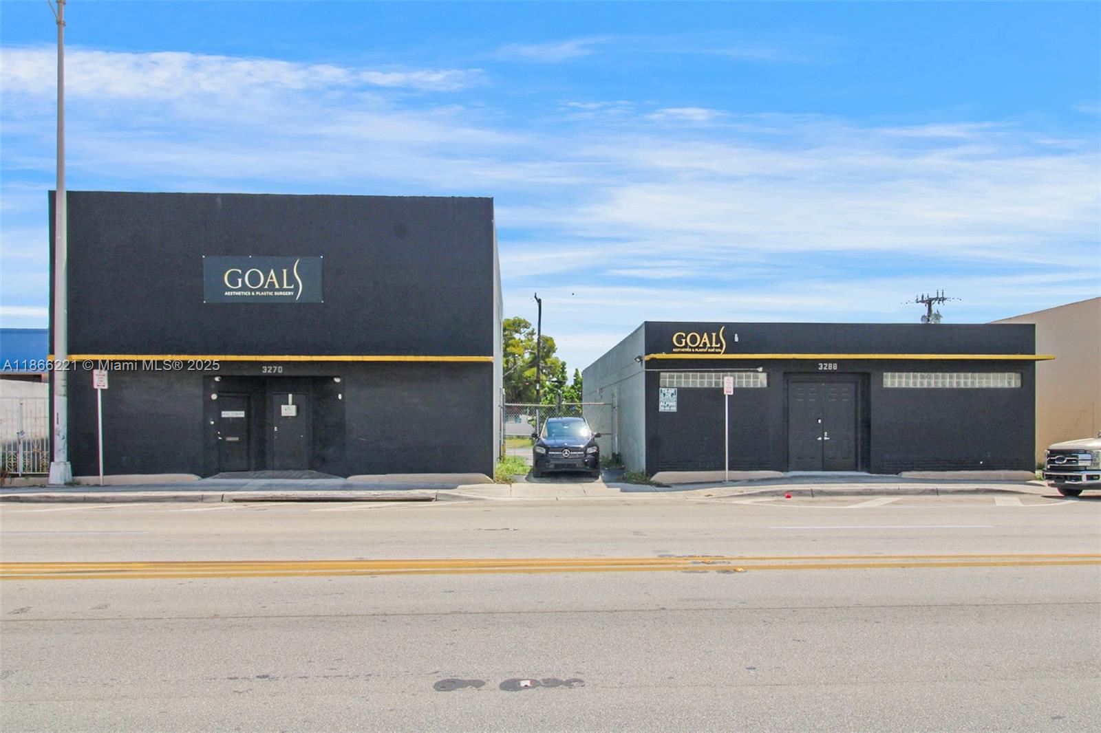 Two black commercial buildings with gold signage stand side-by-side along a paved street — 3267 NW 35th St, Miami FL 33142, MIAMI, FL