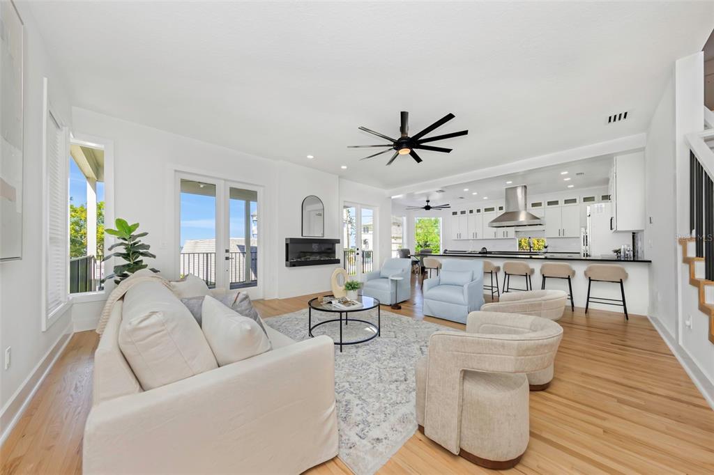 A modern kitchen features white cabinets, a large island with a gas range, and hardwood floors — 606 INDIANA AVENUE, CRYSTAL BEACH, FL