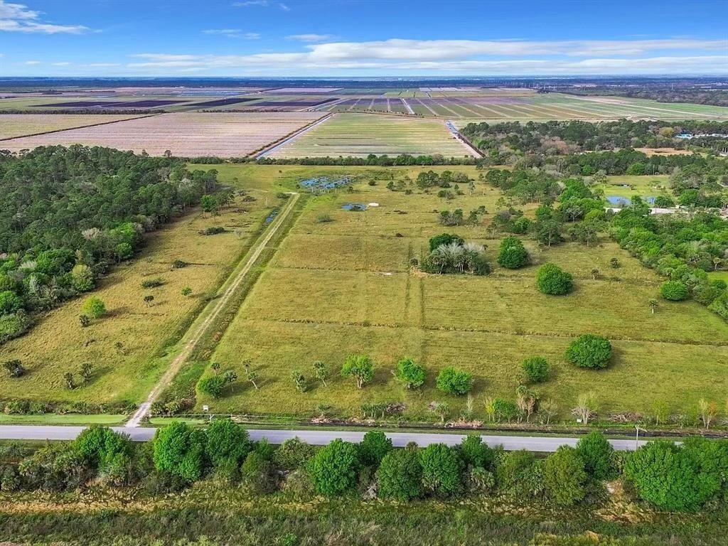 An aerial view shows a large, grassy rural lot bordered by a road and trees — 2777 Everhigh Acres Road Road, Clewiston FL 33440, CLEWISTON, FL