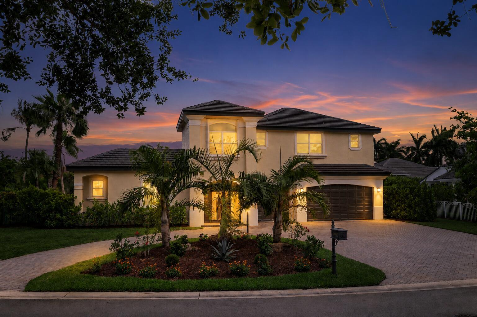 A two-story stucco house with a tile roof and palm trees at dusk — 6569 NW 103rd Terrace, Parkland FL 33076, PARKLAND, FL