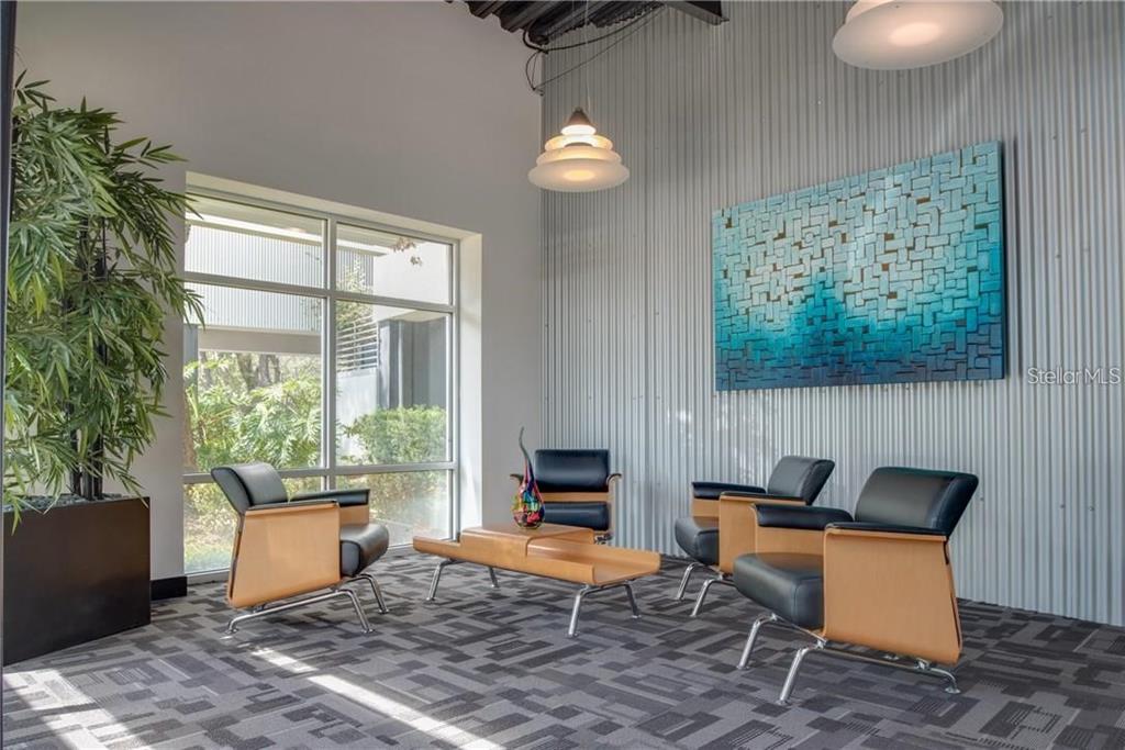 A modern office waiting area features four leather chairs, a coffee table, and corrugated walls — 429 S KELLER ROAD UNIT 310, ORLANDO, FL