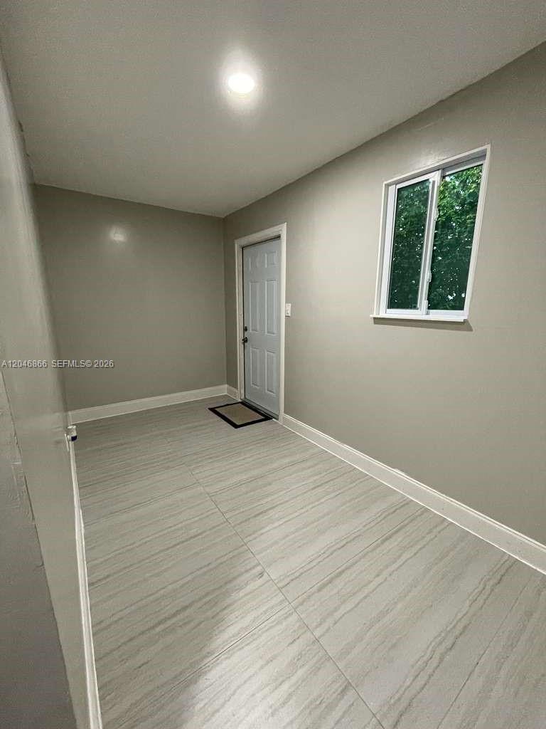 A small room features light gray walls, a white door, and light-colored wood-look tile flooring — 11730 SW 172nd St # 0, Miami FL 33177, MIAMI, FL