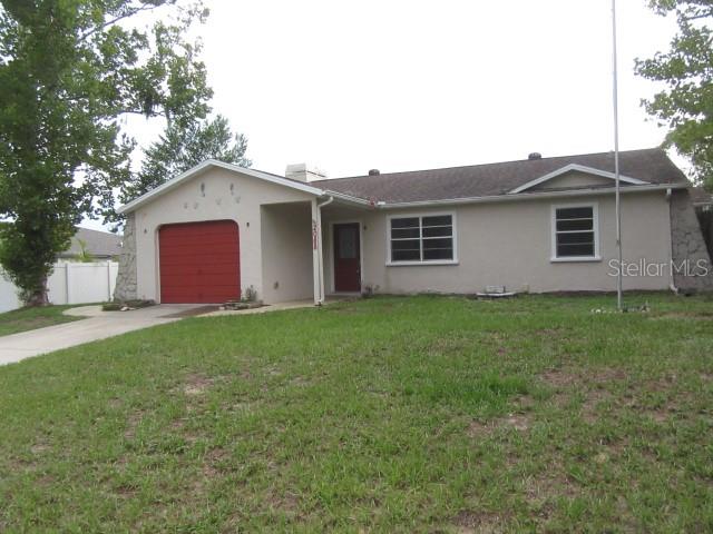 A single-story house with a red garage door, light-colored stucco walls, and a shingled roof — 2088 BOLGER AVENUE, SPRING HILL, FL
