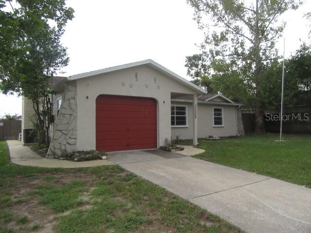 A single-story house with a red garage door, stone accents, and a concrete driveway — 2088 BOLGER AVENUE, SPRING HILL, FL