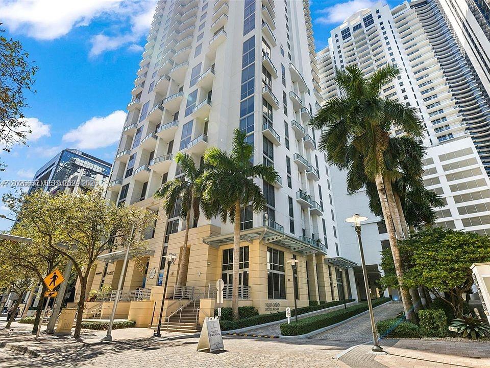 A low-angle exterior view of a tall residential high-rise building with palm trees — 1060 Brickell Ave # 3915, Miami FL 33131, MIAMI, FL