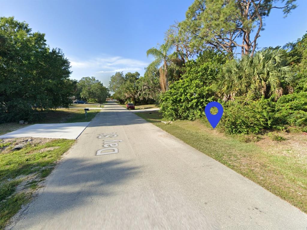 A paved street with a blue location pin marking a wooded lot on the right — 4203 DAY STREET, PORT CHARLOTTE, FL