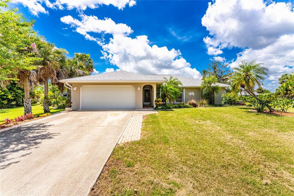 A single-story house with a white garage door, a front entrance, and a concrete driveway — 5105 ACKLEY TERRACE, PORT CHARLOTTE, FL