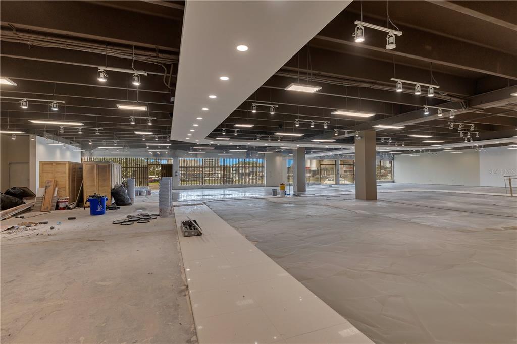 An unfinished commercial space features an exposed ceiling, track lighting, and a central tiled walkway — 65 Avenida de Infanteria CONCORDIA GARDENS SHOPPING CENTER ANNEX BULDING AVENUE, SAN JUAN, PR
