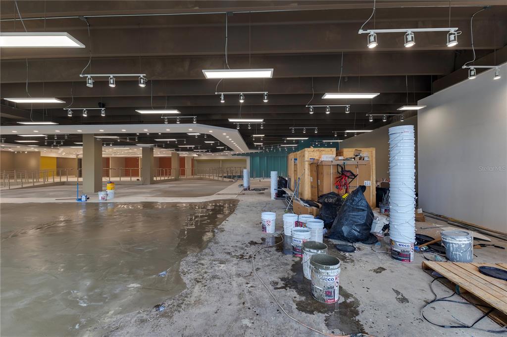 An unfinished commercial interior features exposed ceiling beams, track lighting, and construction materials on concrete floors — 65 Avenida de Infanteria CONCORDIA GARDENS SHOPPING CENTER ANNEX BULDING AVENUE, SAN JUAN, PR