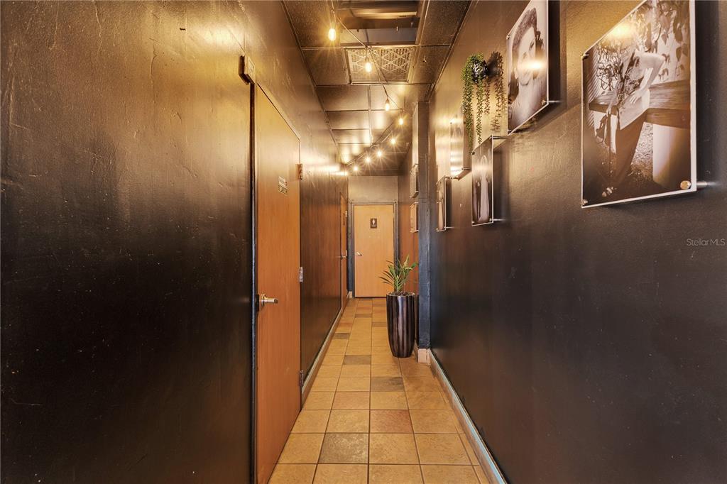 A narrow hallway with black walls, tiled flooring, string lights, and framed wall art — 65 Avenida de Infanteria CONCORDIA GARDENS SHOPPING CENTER ANNEX BULDING AVENUE, SAN JUAN, PR