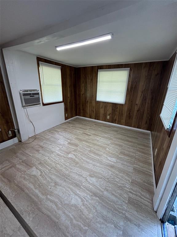 A room with wood-paneled walls, light-colored tile flooring, a window air conditioner, and two windows — 3414 DOCTOR LOVE ROAD UNIT C, ORLANDO, FL
