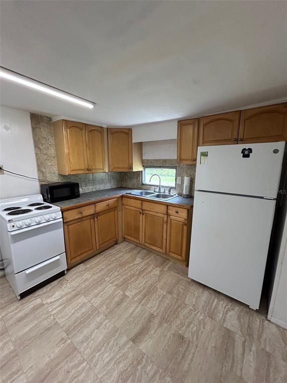 A kitchen features wood cabinets, a white stove, a white refrigerator, and tile flooring — 3414 DOCTOR LOVE ROAD UNIT C, ORLANDO, FL