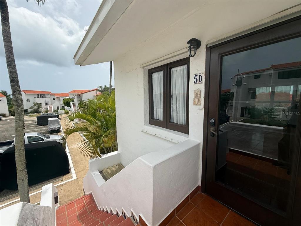 An exterior view of a white building entrance with a brown door labeled 5D — Cluster 2 6000 RIO MAR BOULEVARD UNIT 5D, RIO GRANDE, PR