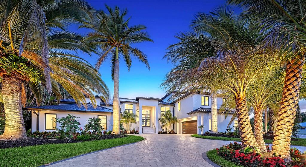 A modern two-story house with a paved driveway and palm trees at twilight — 1516 RIDGEWOOD LANE, SARASOTA, FL