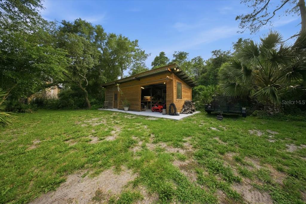 A two-story log cabin home with a gravel driveway and a large screened-in porch — 1630 STILLMEADOW ROAD, DELTONA, FL