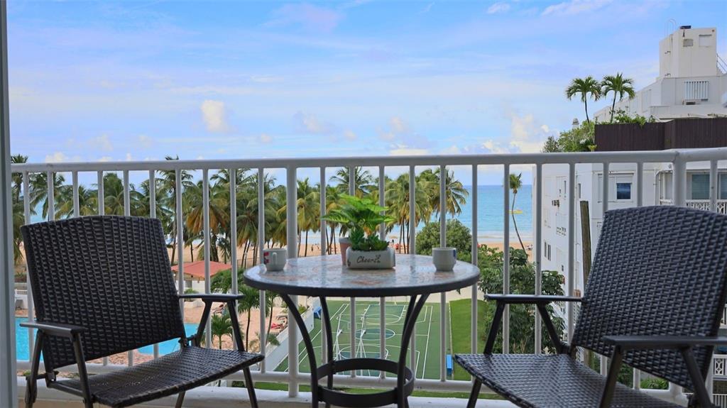 A balcony features two chairs, a small table with a plant, and a beach view — MARBELLA DEL CARIBE ESTE UNIT 508, CAROLINA, PR