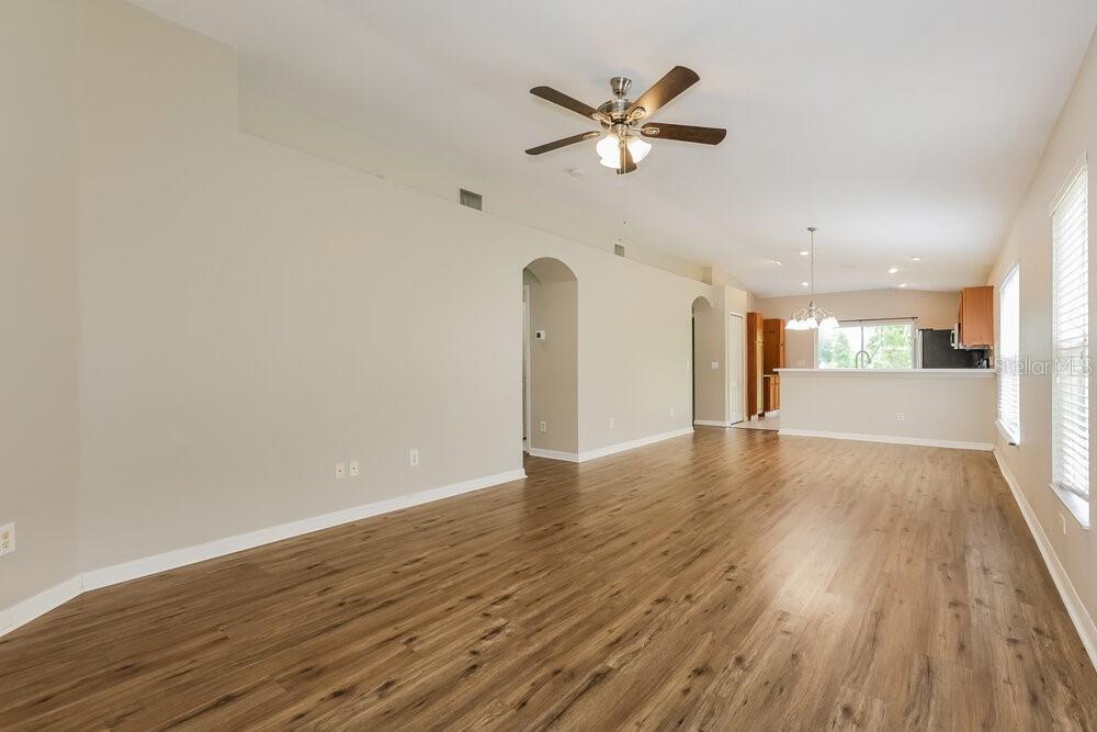 An open-concept living area features wood-look flooring, a ceiling fan, and a kitchen breakfast bar — 12706 WHITE BLUFF ROAD, HUDSON, FL