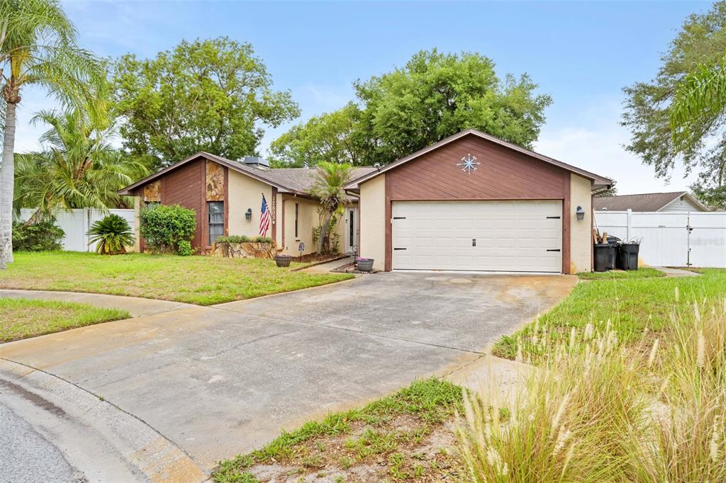 A single-story house with a two-car garage, stone accents, and a front yard — 12803 RED MAPLE COURT, HUDSON, FL