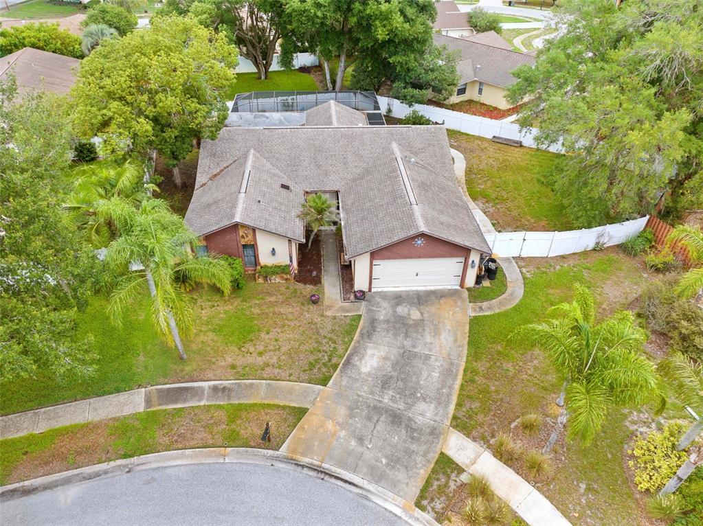 An aerial view of a single-story house with a shingled roof, garage, and swimming pool — 12803 RED MAPLE COURT, HUDSON, FL