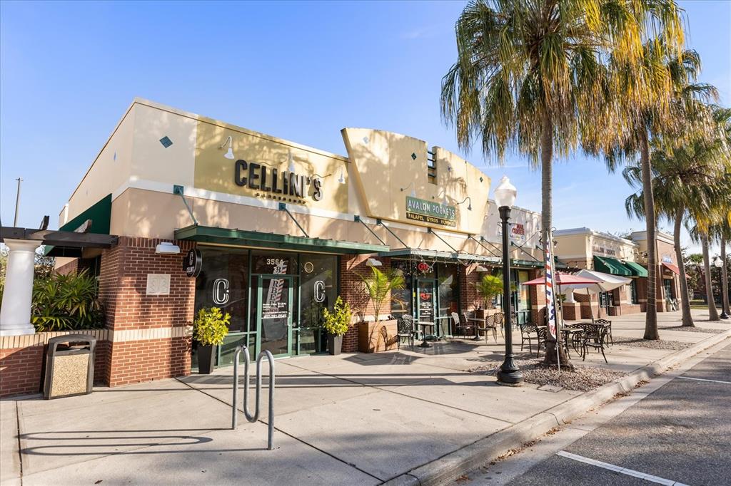 A commercial building exterior features a barbershop and restaurant with outdoor seating and palm trees — 3564 AVALON PARK BOULEVARD, ORLANDO, FL