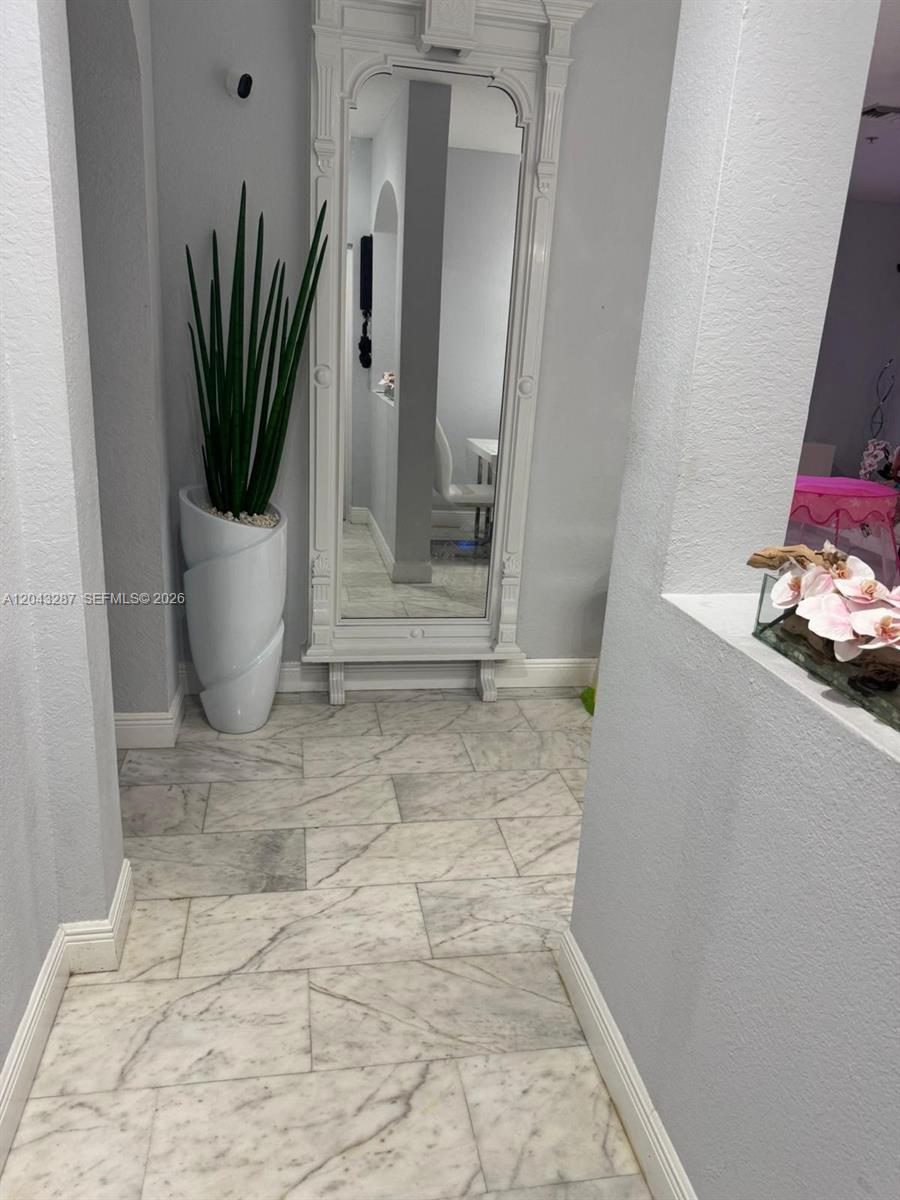 A hallway features marble tile flooring, a tall white floor mirror, and a potted plant — 4301 SW 160th Ave # 215, Miramar FL 33027, MIRAMAR, FL