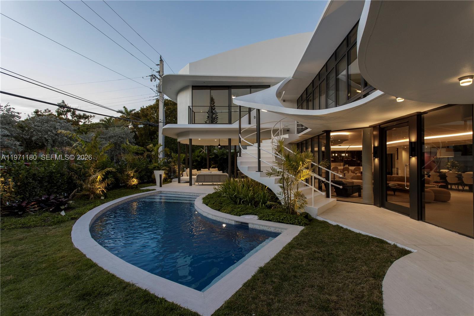 A modern two-story house features a curved white exterior, a spiral staircase, and a pool — 5261 NE 5th Ave, Miami FL 33137, MIAMI, FL