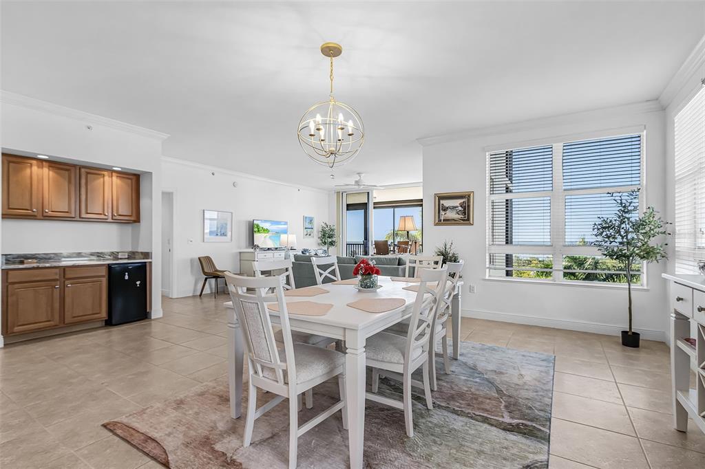 A dining area with a white table and chairs sits before a living room — 3321 SUNSET KEY CIRCLE UNIT 309, PUNTA GORDA, FL