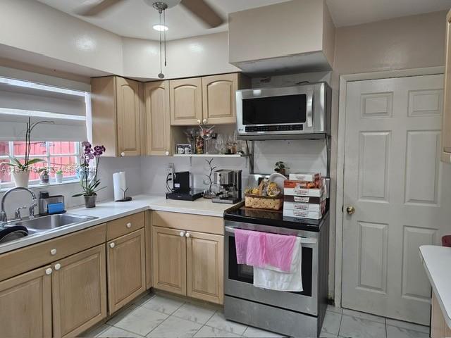 A kitchen features light wood cabinets, stainless steel appliances, and a white door — 8930 SW 197th Ter, Cutler Bay FL 33157, CUTLER BAY, FL