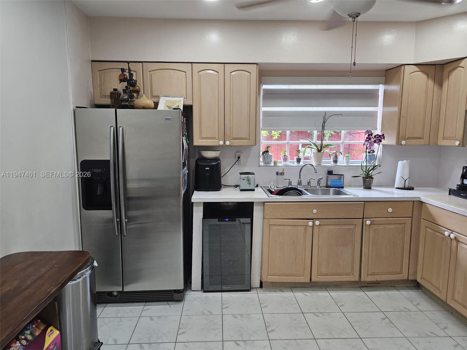 A kitchen features light wood cabinets, stainless steel appliances, a wine cooler, and tile flooring — 8930 SW 197th Ter, Cutler Bay FL 33157, CUTLER BAY, FL