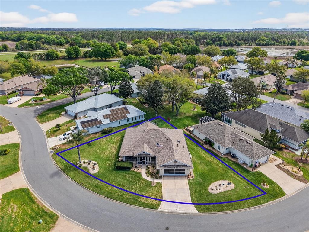 An aerial view shows a single-story house with a blue-outlined yard on a cul-de-sac — 21811 KING HENRY AVENUE, LEESBURG, FL