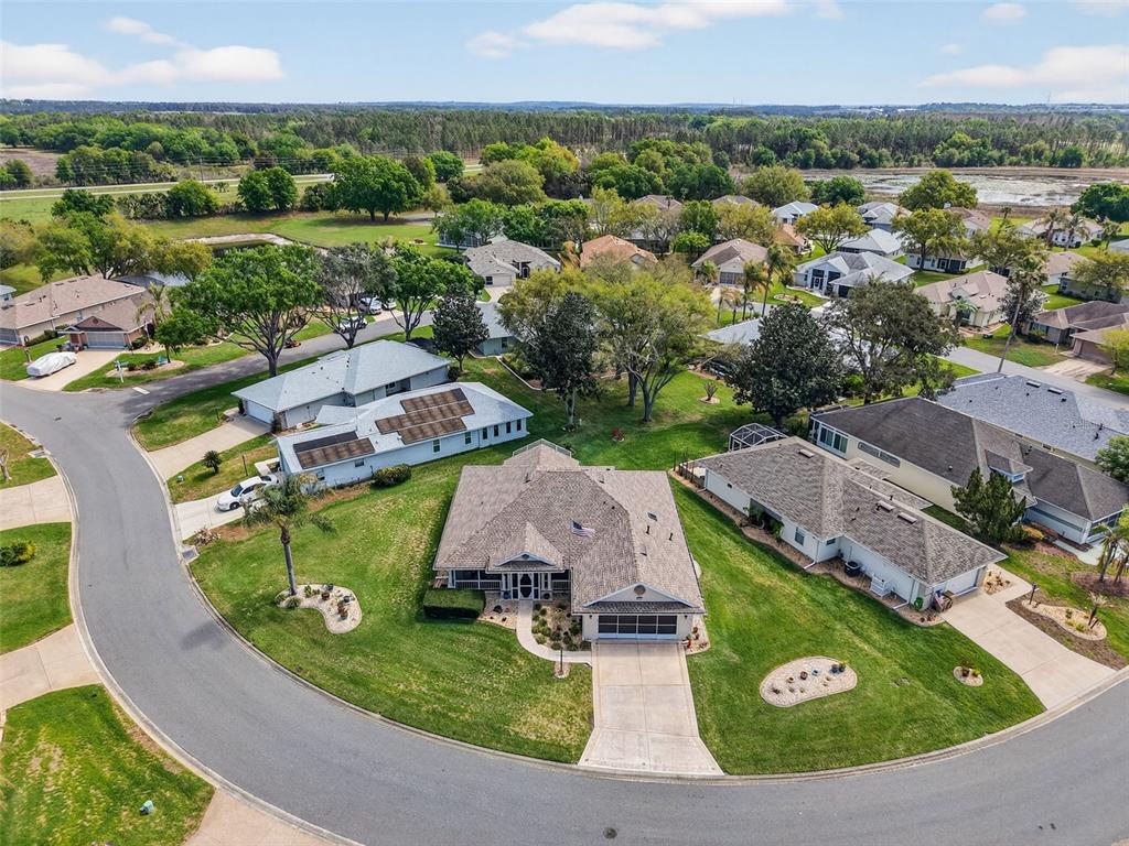 An aerial view shows a suburban neighborhood with single-family homes and manicured lawns — 21811 KING HENRY AVENUE, LEESBURG, FL