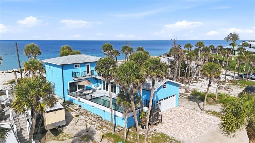 An aerial view of a bright blue two-story house with a pool and palm trees — 4074 N BEACH ROAD, ENGLEWOOD, FL