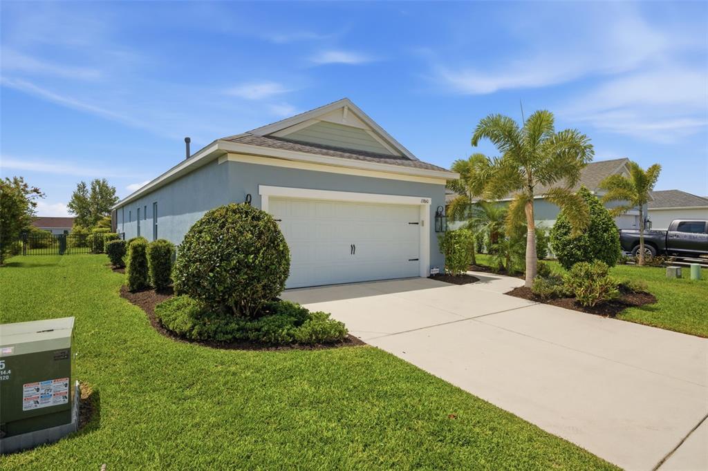 A single-story house with a blue exterior, a two-car garage, and a manicured lawn — 13860 OLD CREEK COURT, PARRISH, FL