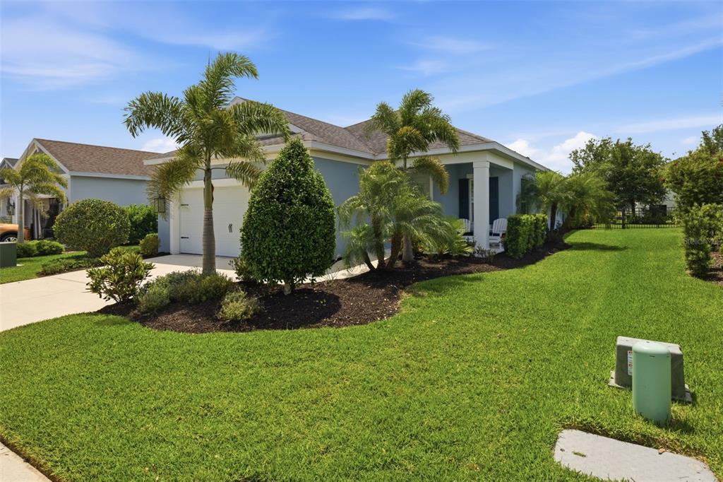 A single-story house with a white garage, palm trees, and a green lawn — 13860 OLD CREEK COURT, PARRISH, FL