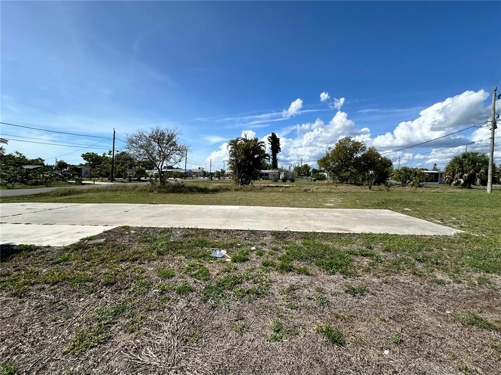 A vacant lot features a concrete slab foundation under a bright blue sky — 1427 SEAGULL DRIVE, ENGLEWOOD, FL