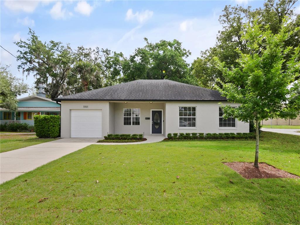 A single-story house with a light-colored exterior, a one-car garage, and a front lawn — 1801 FORMOSA AVENUE, ORLANDO, FL