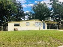 A single-story house with light yellow siding and an attached carport sits on a lawn — 240 LEE DRIVE, ORANGE PARK, FL