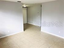 An interior view of a room with light gray walls and light-colored tile flooring — 240 LEE DRIVE, ORANGE PARK, FL