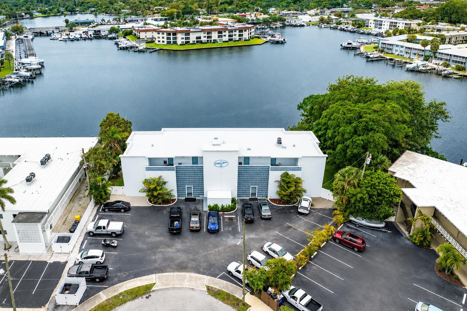 An aerial view shows a white apartment building with a parking lot and waterfront docks — 628 Southwind Circle, North Palm Beach FL 33408, NORTH PALM BEACH, FL