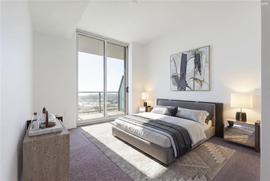 A bedroom with a gray bed, a patterned rug, and a balcony overlooking the water — 400 CENTRAL AVENUE UNIT 3506, ST PETERSBURG, FL