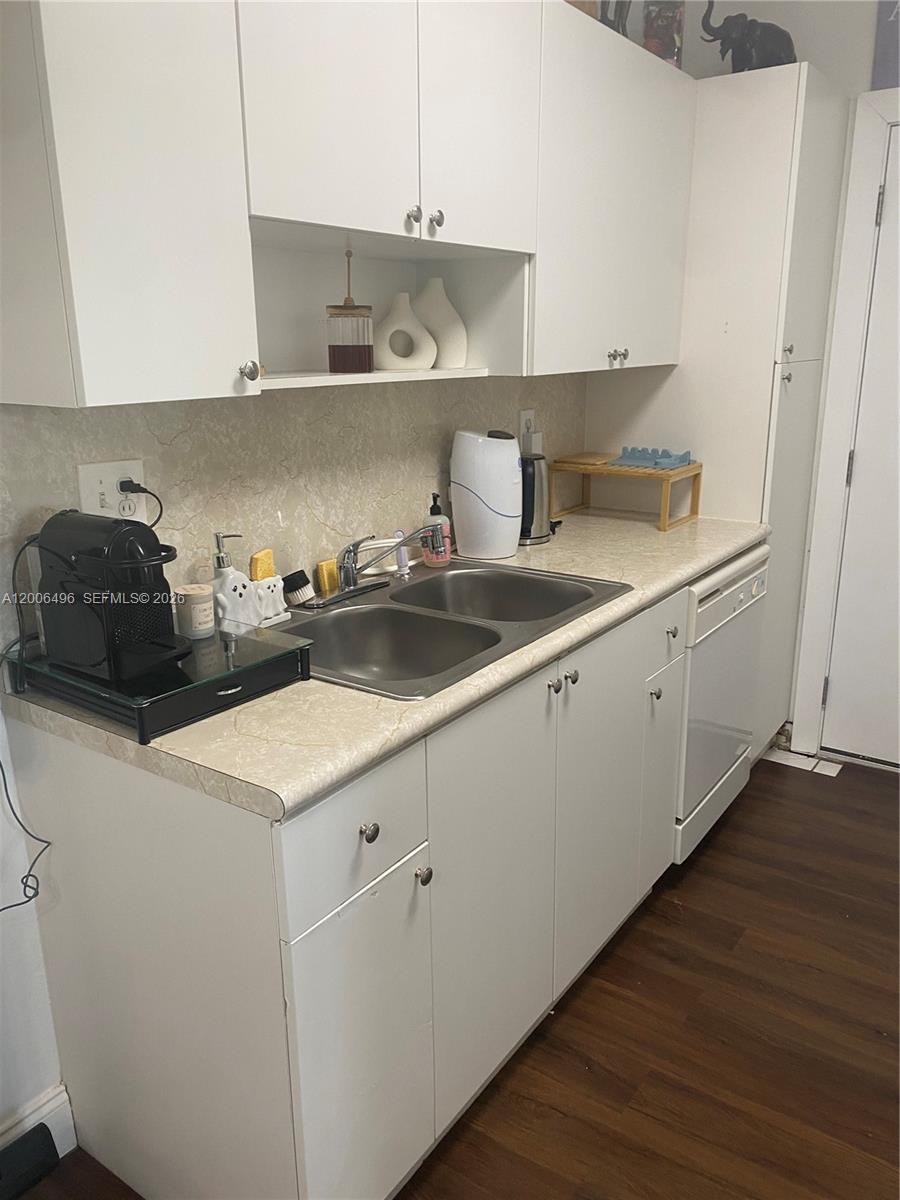 A kitchen features white cabinets, a double-basin stainless steel sink, and light-colored laminate countertops — 900 SW 84th Ave # 415D, Miami FL 33144, MIAMI, FL