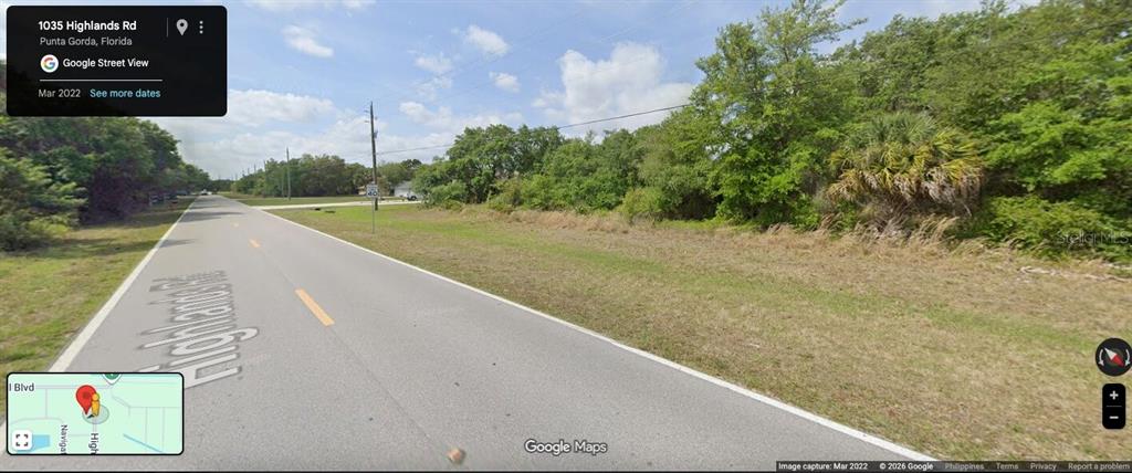 A street view shows a paved road bordered by a grassy shoulder and dense trees — 1035 HIGHLANDS ROAD, PUNTA GORDA, FL