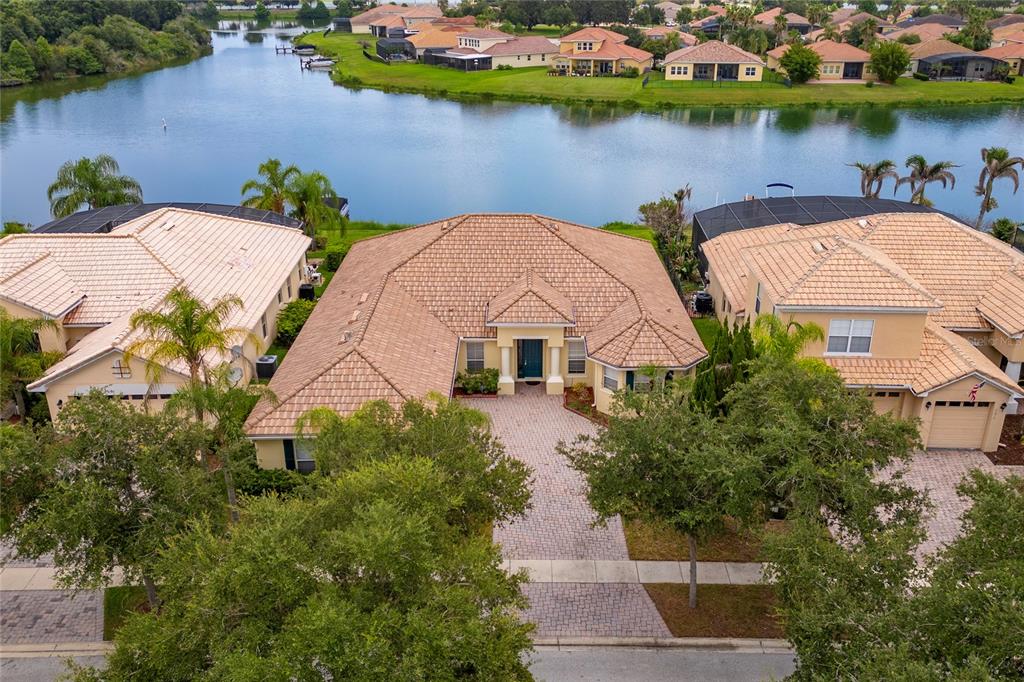 An aerial view of a single-story house with a tiled roof and a paved driveway — 3817 GOLDEN FEATHER WAY, KISSIMMEE, FL
