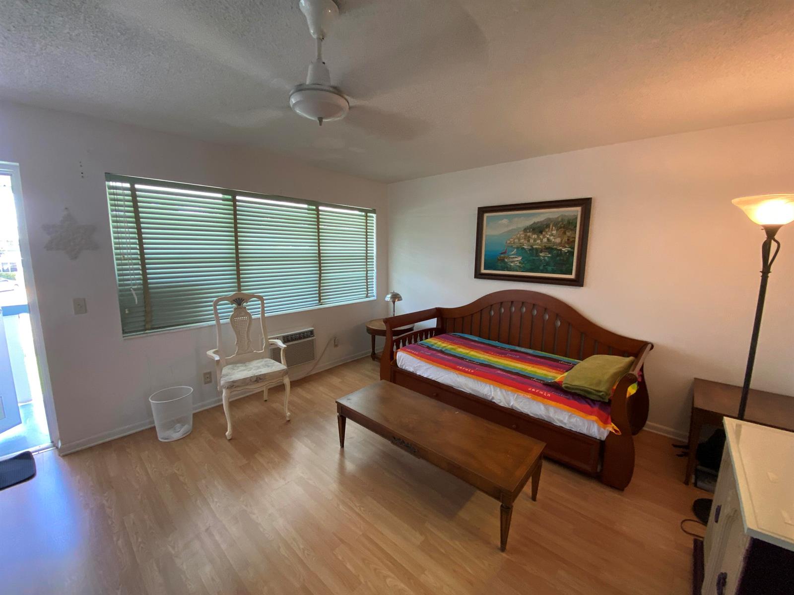 A living room features a wooden daybed, a coffee table, a white chair, and blinds — 71 Berkshire # 71, West Palm Beach FL 33417, WEST PALM BEACH, FL
