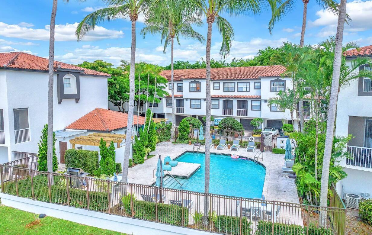An aerial view of a swimming pool surrounded by a fence and multi-story apartment buildings — 20889 Saint Andrews Boulevard, Boca Raton FL 33433, BOCA RATON, FL