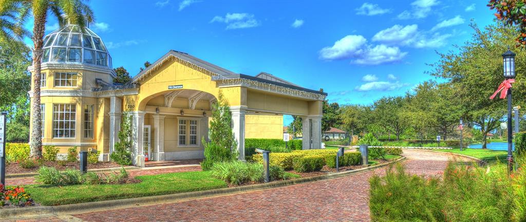 A yellow building with a glass dome and a covered entrance sits beside a brick road — 698 MAHOGANY RUN, PALM COAST, FL