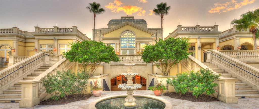 A grand estate exterior features a central fountain, symmetrical staircases, and a glass-topped conservatory — 698 MAHOGANY RUN, PALM COAST, FL