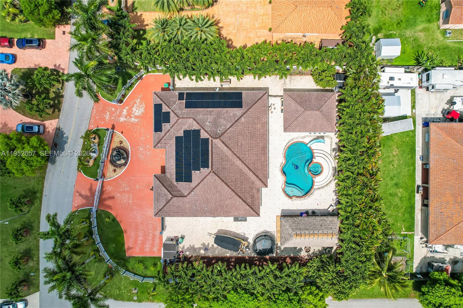 An aerial view shows a house with solar panels, a pool, and a large patio — 12969 SW 220th Ter, Miami FL 33170, MIAMI, FL