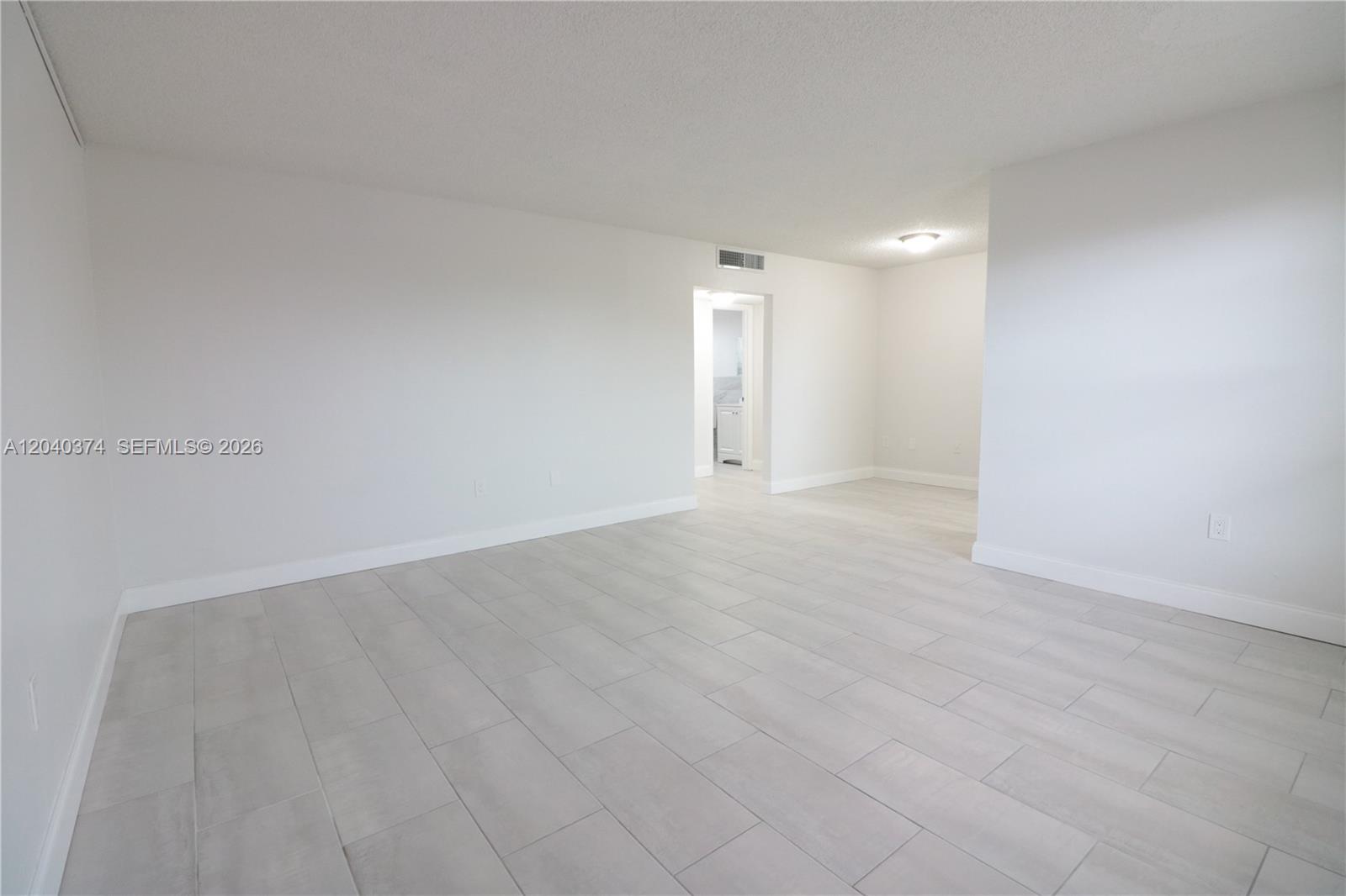 An empty room features white walls, light gray tile flooring, and a doorway leading elsewhere — 400 NE 1st St # 108, Hallandale Beach FL 33009, HALLANDALE BEACH, FL