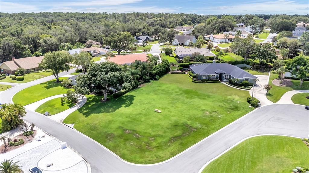 An aerial view shows a vacant grassy lot situated between two suburban houses — PIER PLACE DRIVE, LAKELAND, FL